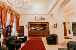 uma sala de espera com cadeiras e um bar em Tisza Hotel em Szeged