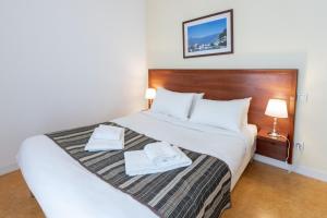 1 dormitorio con 1 cama con 2 toallas en Residhotel Grenette en Grenoble