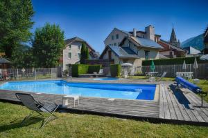 a swimming pool with a slide in a yard at Hotel du Col de l'Arc in Lans-en-Vercors