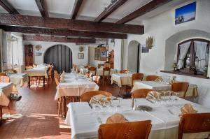a restaurant with tables and chairs with white tablecloths at Hotel du Col de l'Arc in Lans-en-Vercors