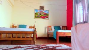 a room with two beds and a painting on the wall at CDH Backpackers in Mombasa