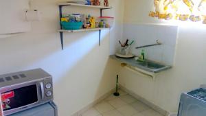 a kitchen with a sink and a microwave at CDH Backpackers in Mombasa +32 photos