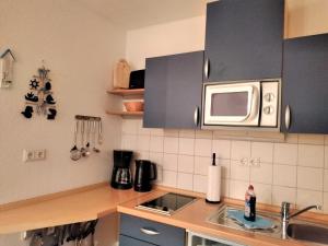een keuken met een spoelbak en een magnetron bij Koserow_Jugendweg_FeWo 16 in Ostseebad Koserow +7 foto's