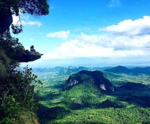 a person sitting on a cliff in the mountains at Amazing Backpackers Hostel AoNang in Ao Nang Beach