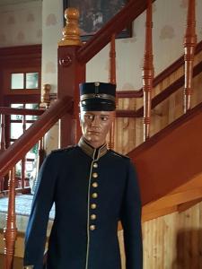 a man in a uniform standing next to a staircase at Skogsbrynet B&B, Bredsjö Nya Herrgård in Hällefors