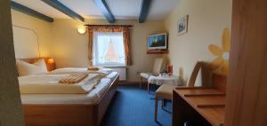 um quarto de hotel com uma cama e uma janela em Hotel Schatthaus em Greetsiel