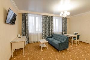 a living room with a blue couch and a table at Hotel Aquamarin in Surgut