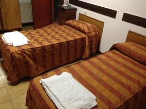 a hotel room with two beds with towels on them at Monastero San Vincenzo - Casa Per Ferie in Bassano Romano