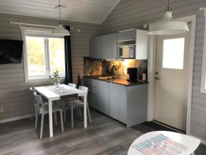 a kitchen and dining room with a table and a table and a tablektop at Saltviks Stugby & Camping in Grebbestad