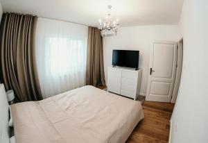 a bedroom with a bed and a flat screen tv at Apartament de lux ultramodern in zona centrala in Timişoara