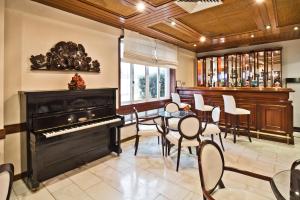 a room with a piano and a table and chairs at Golden Tulip Porto Gaia Hotel in Vila Nova de Gaia