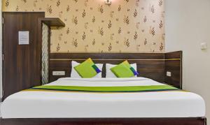 a bedroom with a large bed with green pillows at Treebo Trend Royal Sun Palace MP Nagar Zone 2 in Bhopal