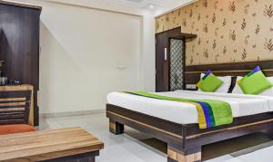 a bedroom with a bed and a chair and a table at Treebo Trend Royal Sun Palace MP Nagar Zone 2 in Bhopal
