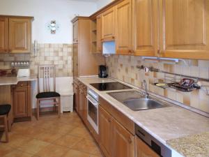 a kitchen with wooden cabinets and a sink at Tamás Ház in Balatonőszöd