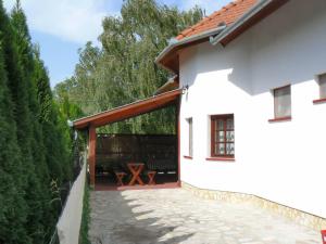 a white house with a patio with a table at Tamás Ház in Balatonőszöd