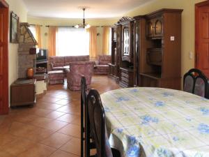 a dining room with a table and a living room at Tamás Ház in Balatonőszöd +3 photos