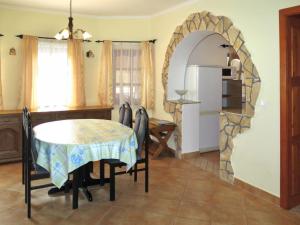 a kitchen and dining room with a table and a refrigerator at Tamás Ház in Balatonőszöd
