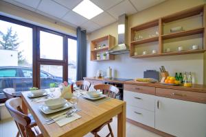 a kitchen with a wooden table with chairs and a dining room at Aparthotel Globus - bezkontaktowa obsługa in Łódź