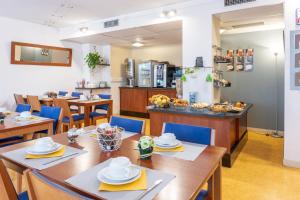 a restaurant with wooden tables and chairs and a kitchen at Residhotel Grenette in Grenoble
