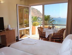 a bedroom with a table and a view of the ocean at Dom Pedro Madeira in Machico