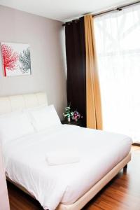 sypialnia z białym łóżkiem i oknem w obiekcie Hotel Kamelia w mieście Kepala Batas