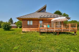 a wooden house with an umbrella and an umbrella at Loges du Jura in Cerniébaud