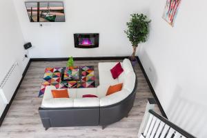 a living room with a white couch with colorful pillows at Curragh House Lodges in Kinsale +10 photos