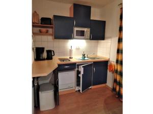 a small kitchen with a sink and a microwave at Koserow_Jugendweg_FeWo 16 in Ostseebad Koserow