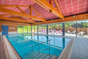 una piscina coperta con acqua blu in un edificio di Loges du Jura a Cerniébaud