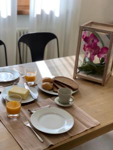 una mesa de madera con platos de comida y bebidas. en Arcovacanze, en Arco