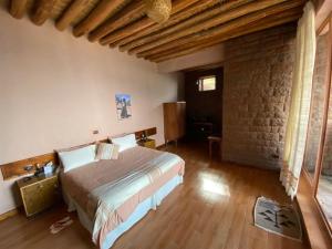 a bedroom with a bed and a brick wall at Ben Abeba Lodge & Tukul in Lalībela