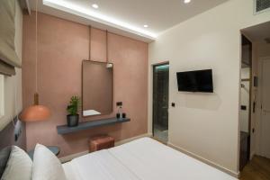 a bedroom with a bed and a mirror at Ederlezi Zoubourlou Aparthotel in Athens