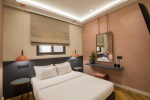 um quarto com uma cama branca e um espelho em Ederlezi Zoubourlou Aparthotel em Atenas