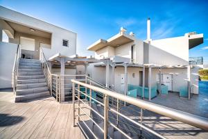 a house with a deck with stairs and a stair railing at Elia Tree Studios in Heraklio Town