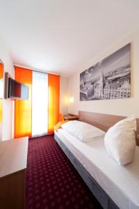 a hotel room with two beds and a tv at McDreams Hotel Wuppertal City in Wuppertal
