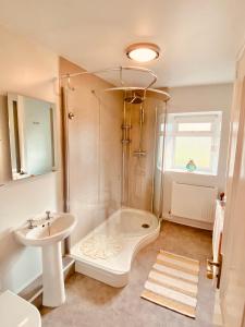 a bathroom with a shower and a sink at Hawkshead Cottage in Glossop