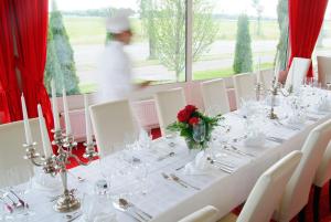 ゾーストにあるHanse Hotelの白いテーブルクロスと花の長いテーブル