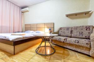 a bedroom with a bed and a couch and a table at 430 Апартаменты в Золотом квадрате в центре Отличный вариант для туристов и командированных in Almaty