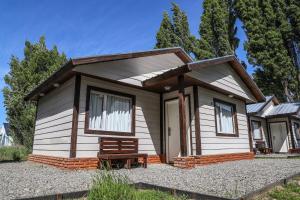 una pequeña casa con un banco delante en Cabañas del Arroyo Calafate (CRyPPSC) en El Calafate