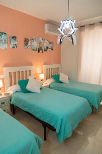 Dos camas en una habitación con sábanas azules. en Pension Internacional, en Córdoba