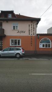 a silver car parked in front of a building at Alföld Panzio & Étterem in Cegléd