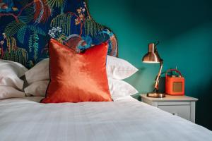 uma almofada vermelha numa cama com uma parede verde em Ralph's em Moira