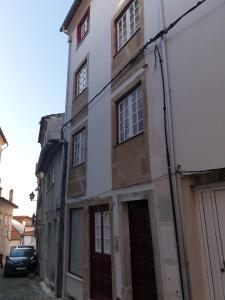an old white building with windows and a garage at Casa do Museu, Museum House in Coimbra