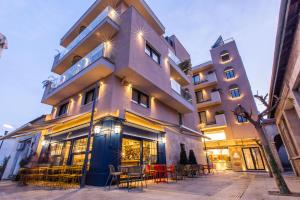 a building with tables and chairs in front of it at Old Port Hotel in Limassol