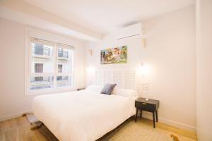 una camera bianca con un letto e una finestra di Apartamentos San Marcial 28 a San Sebastián