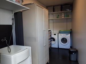 een kleine wasruimte met een wasmachine en droger bij Graviana - Pedra Negra Charming House in Lagoa