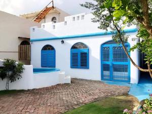a white and blue house with blue shutters at 采雲軒輕旅包棟Villa in Eluan