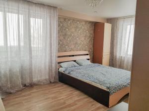 a bedroom with a bed and a window at Апартаменты Кристалл на Пушкина 12 in Yurga