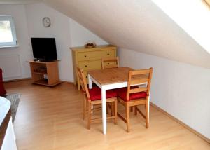 a dining room with a table and chairs and a television at Ferienwohnung Harry im Riesengebirge in Dolní Lánov
