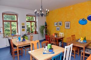 une salle à manger avec des tables et des chaises en bois dans l'établissement Pension Bloo Tomato, à Zittau